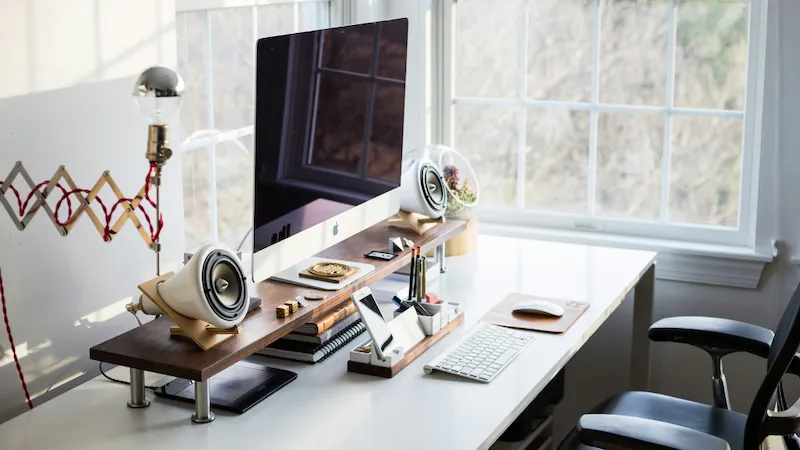 A sleek desk setup featuring an Apple computer surrounded by neatly arranged stationery and other office essentials. The organised and stylish layout creates a professional and efficient workspace, ideal for productivity in a modern office environment